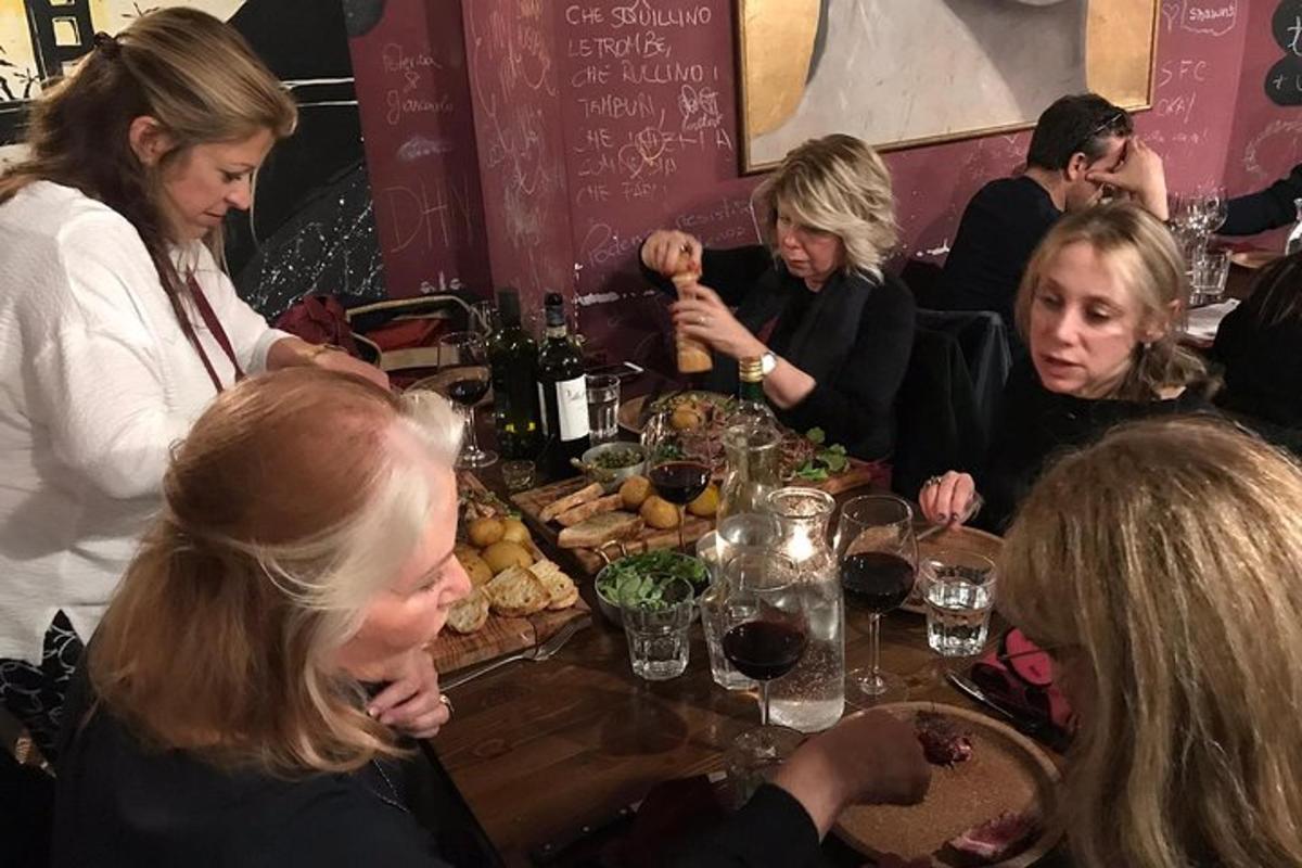 grupp inimesi, kes istuvad laua ümber ja söövad toitu
