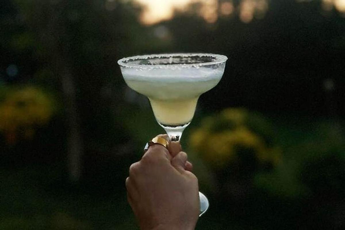 una persona sosteniendo una bebida en una copa de martini