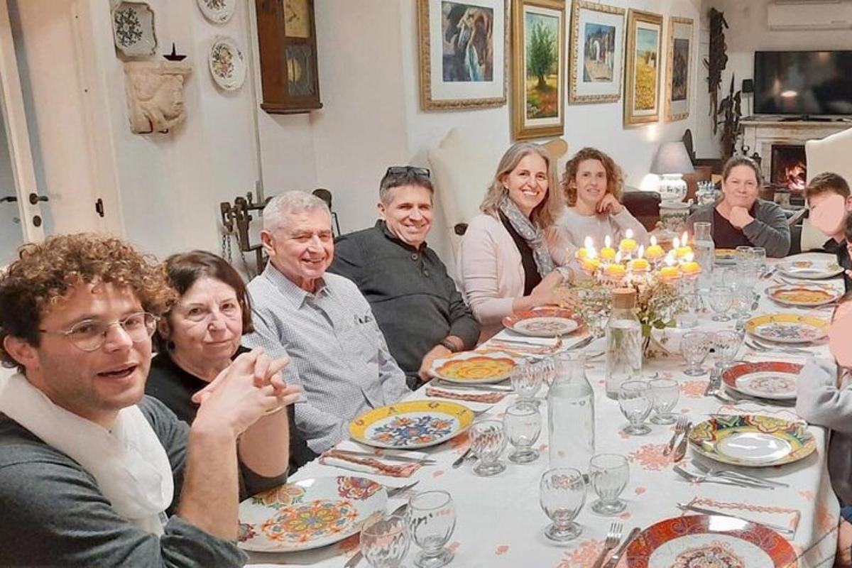 skupina ljudi, ki sedijo za večerno mizo