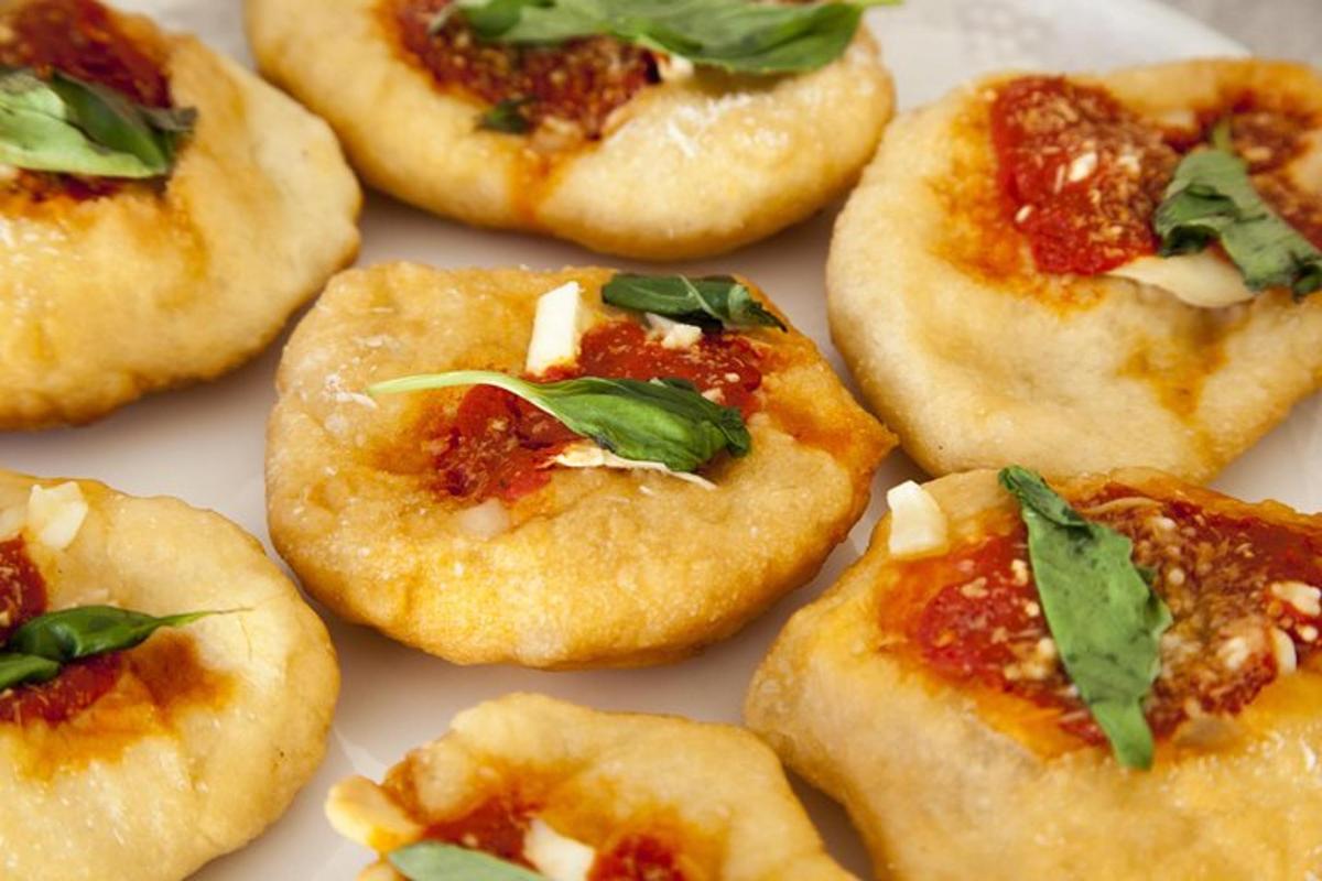 skupina malých pizz s omáčkou a bazalkou