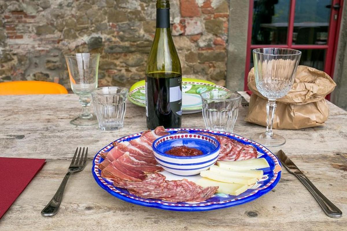 um prato de carne e queijo e uma garrafa de vinho