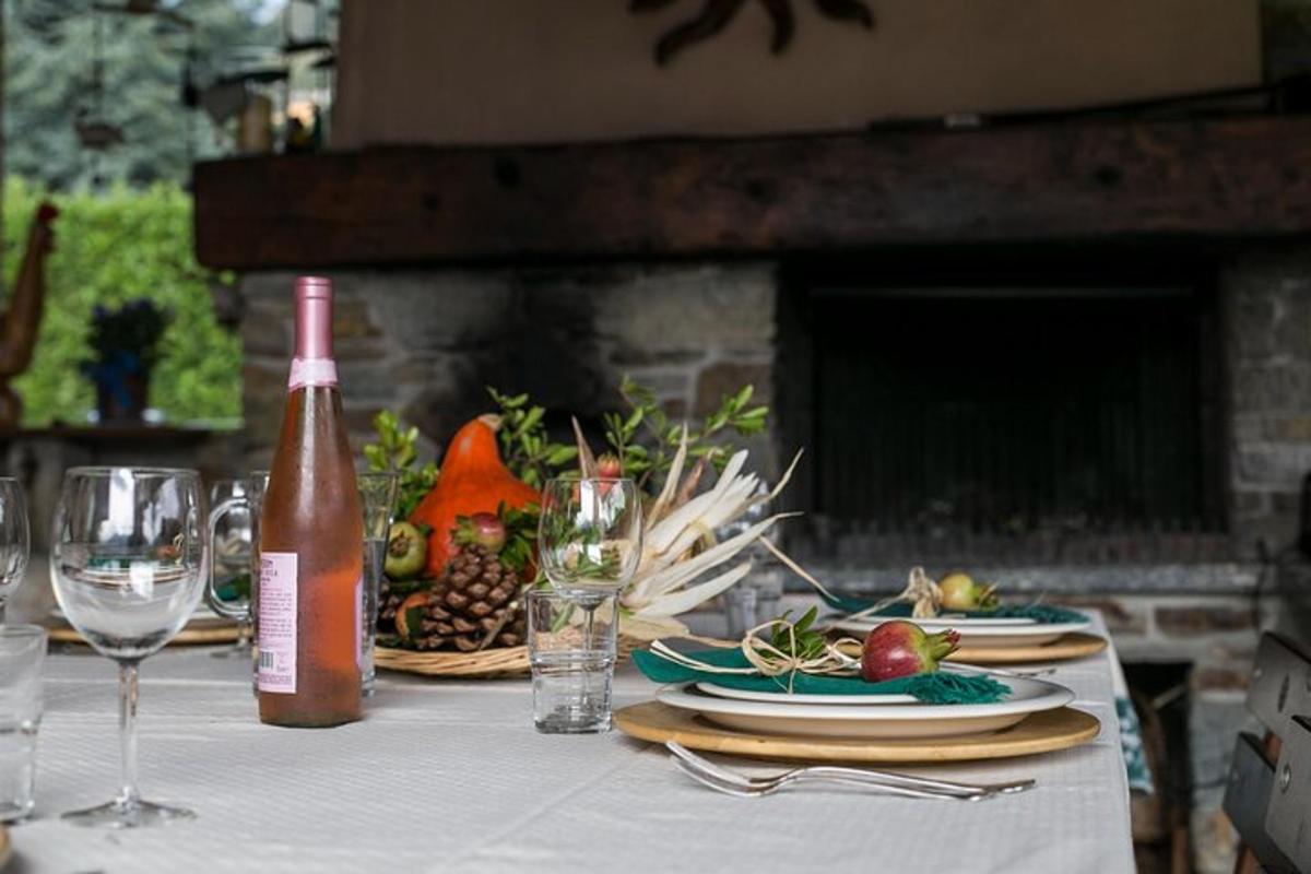 miza s steklenico vina in krožniki hrane