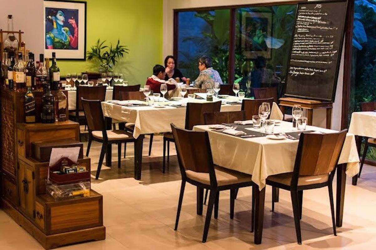 Un restaurante con mesas y sillas con gente sentada en ellas.