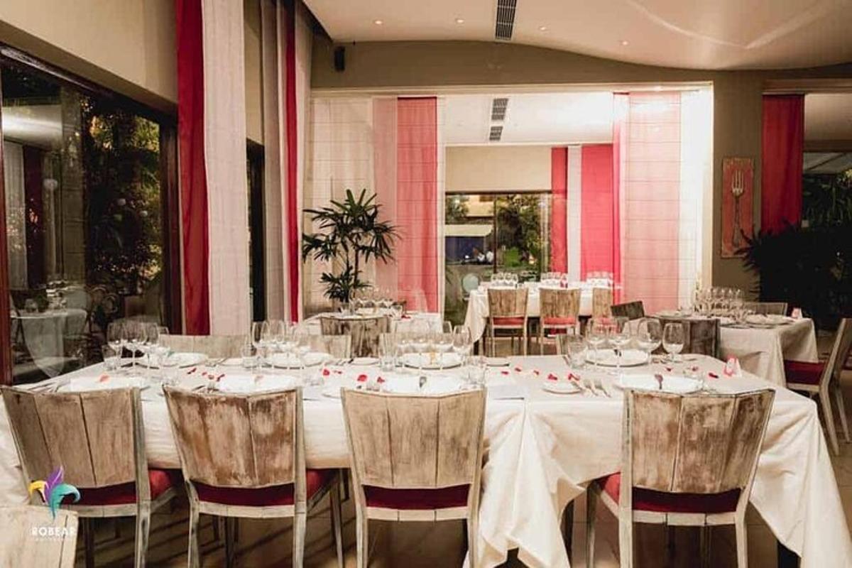 Un gran comedor con mesas y sillas blancas.