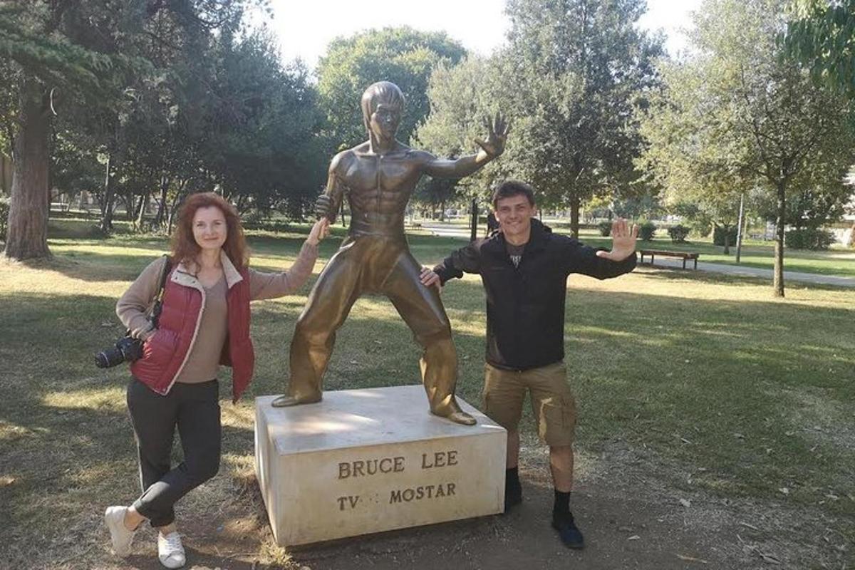 a man and a woman standing next to a statue