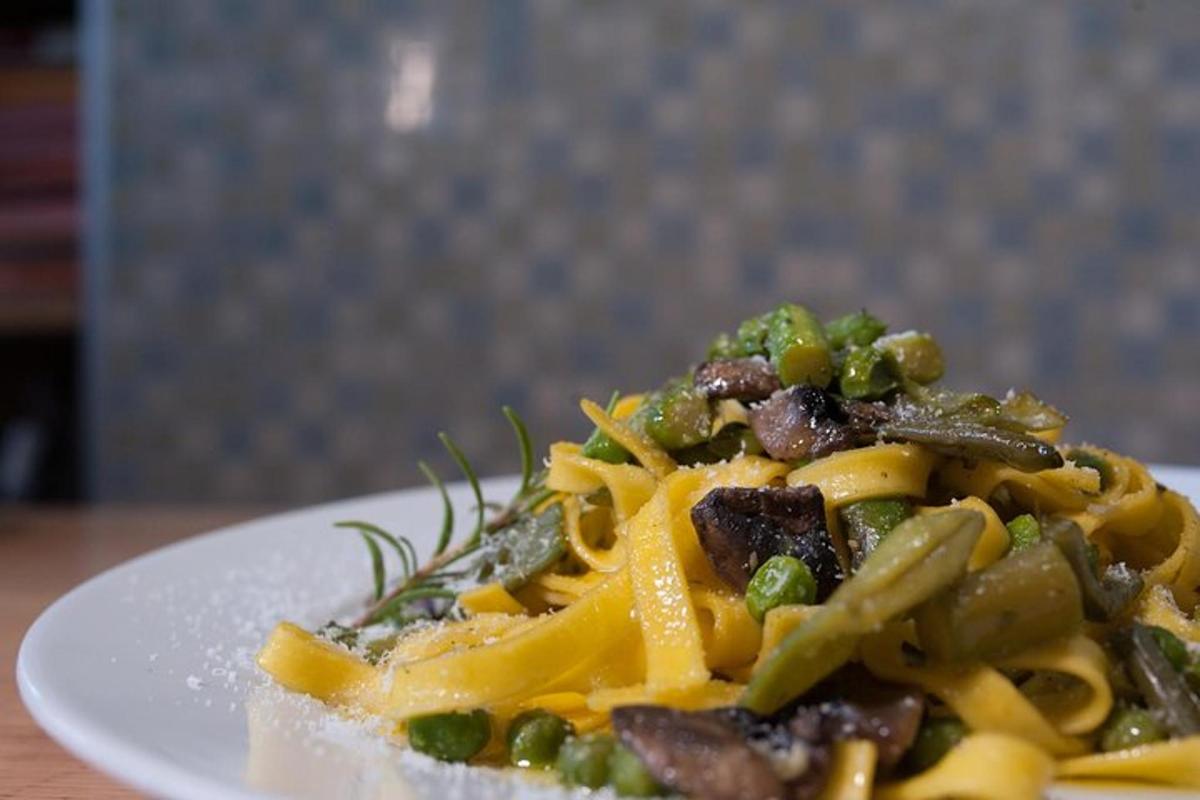 en tallerken pasta med kød og grøntsager på et bord