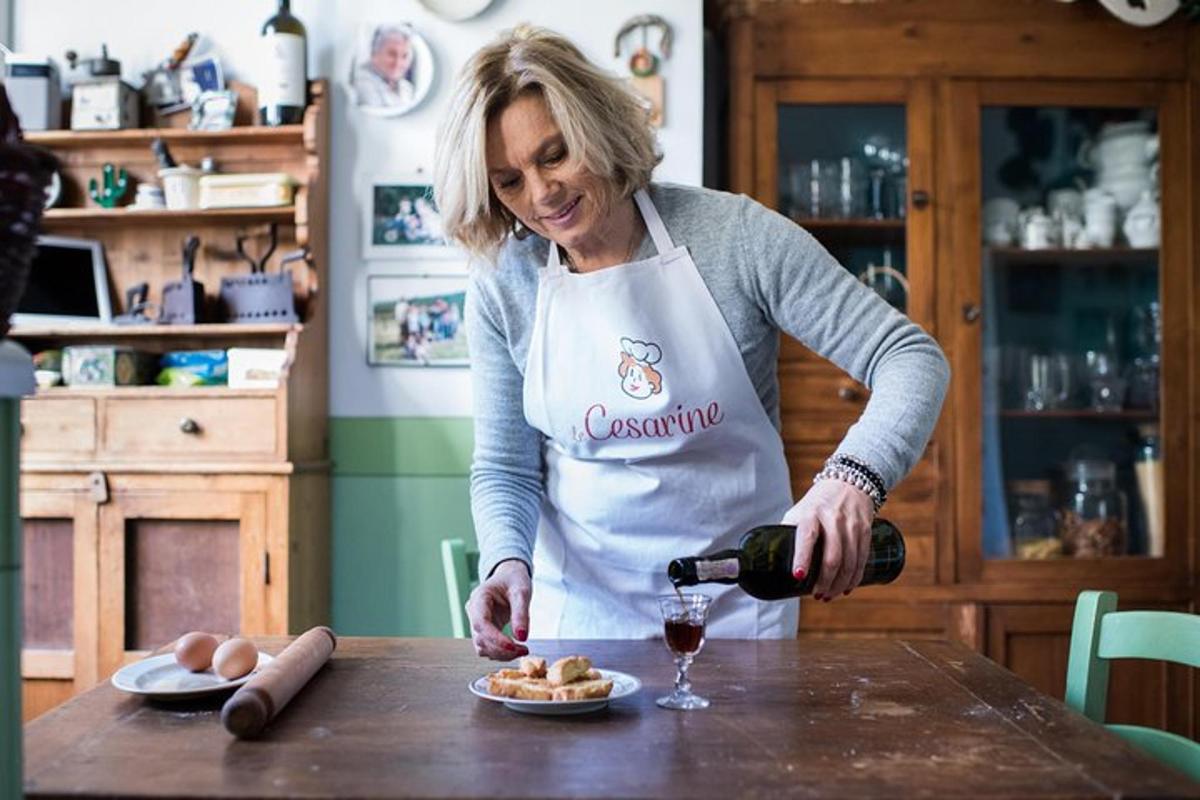 eine Frau in einer Küche schenkt ein Glas Wein ein