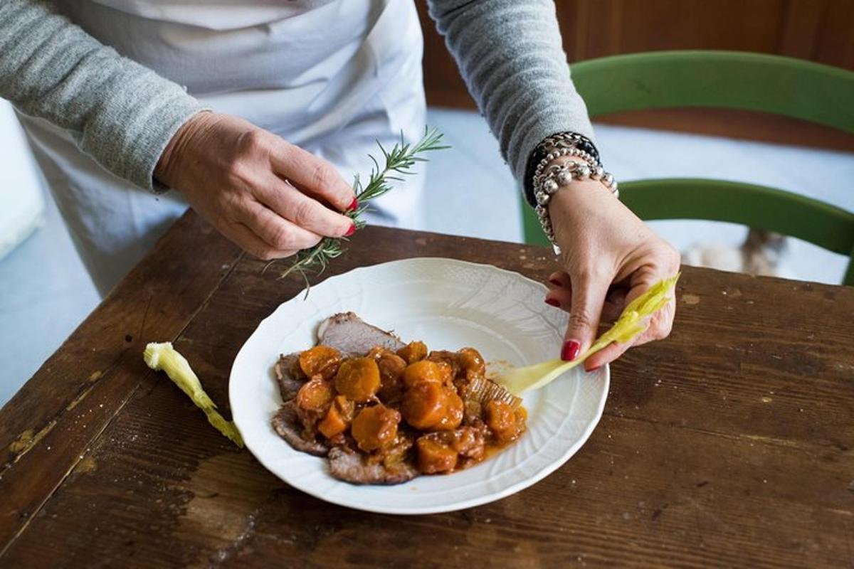 eine Person, die einen Teller mit Essen auf einem Tisch hält