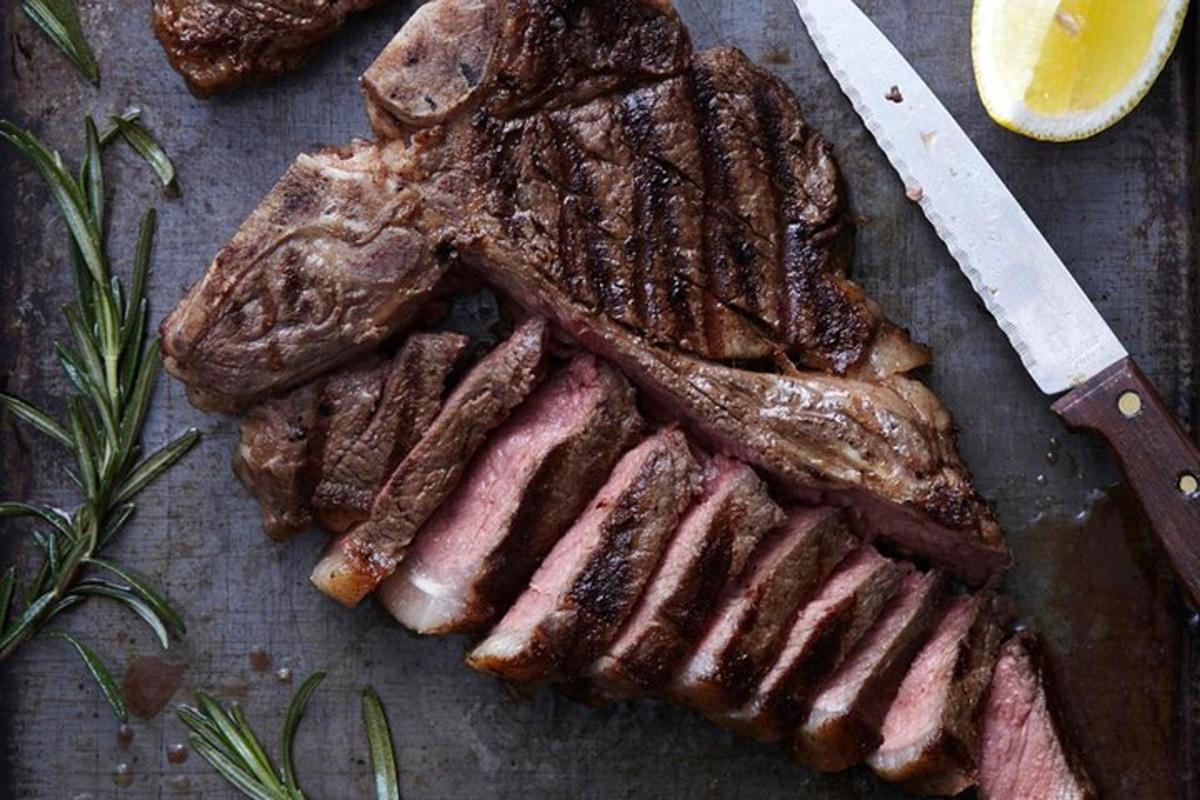 borð með steik, hníf og skurðarbretti