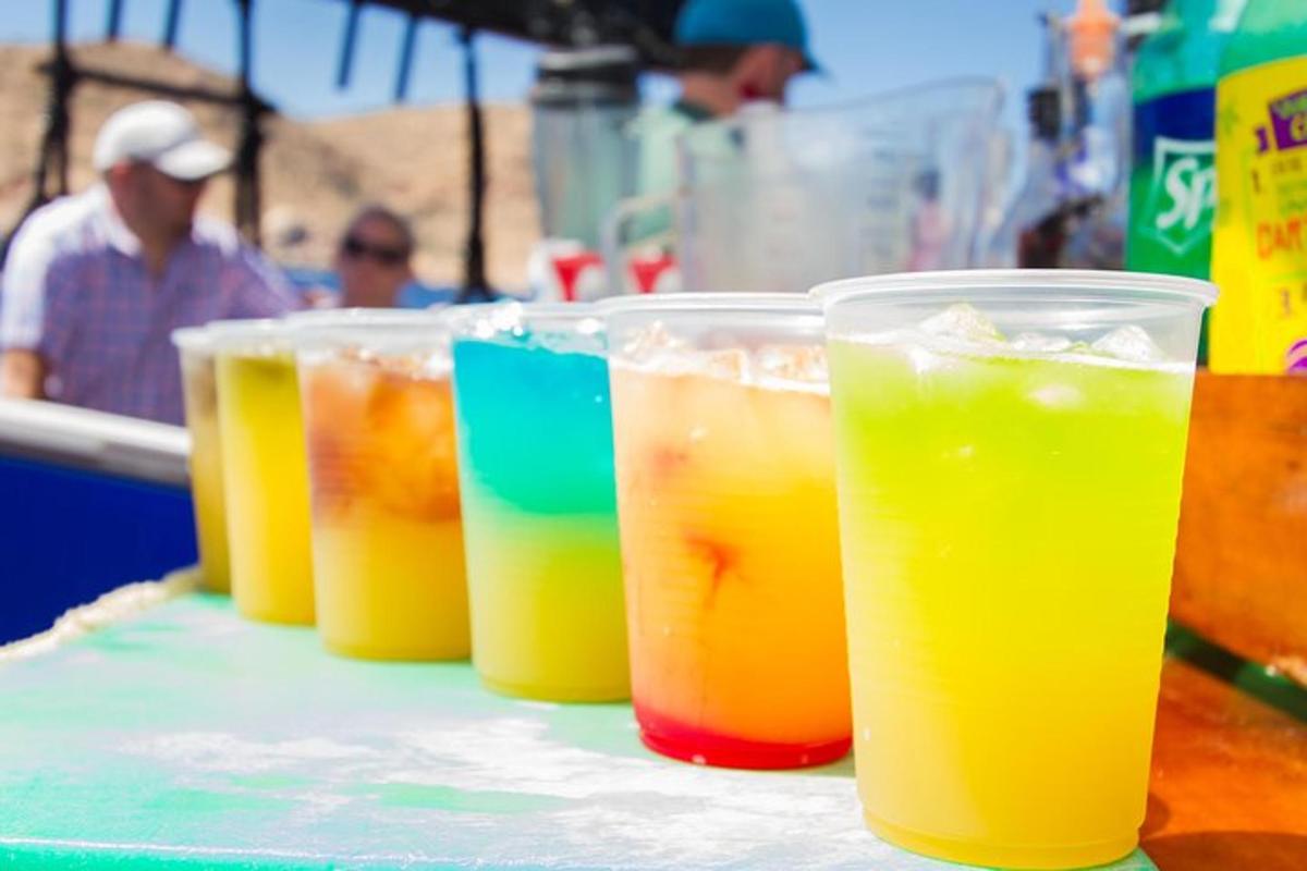 a row of plastic cups filled with drinks on a table
