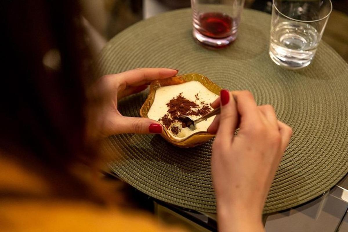 žena sedící u stolu s talířem dezertu