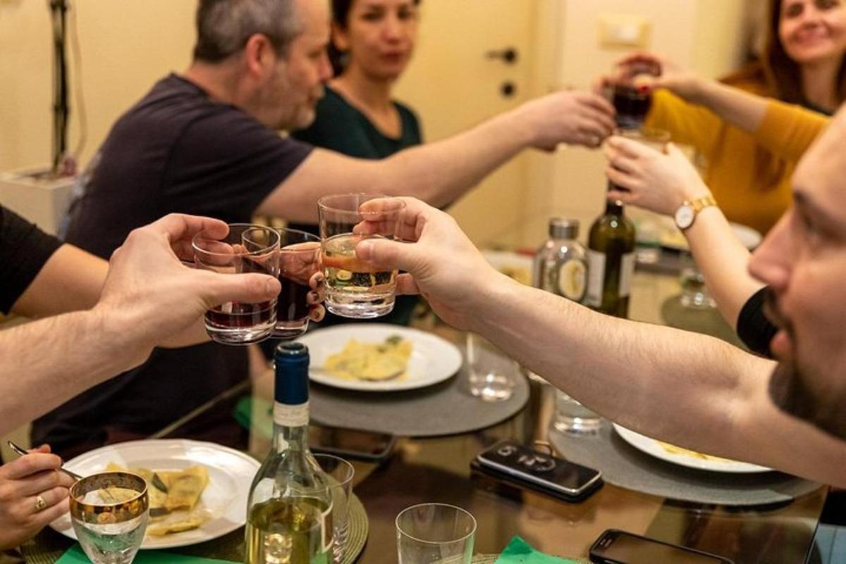 un grup de oameni așezați în jurul unei mese, bând vin