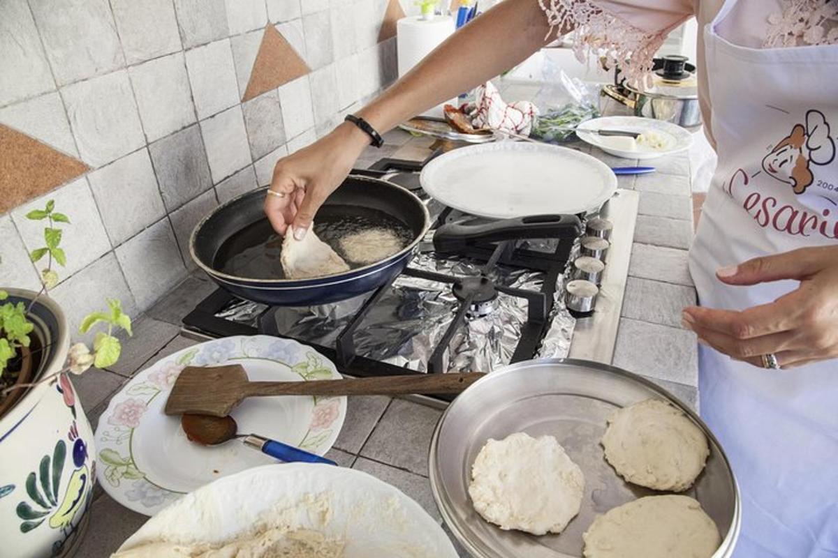 Μια γυναίκα ετοιμάζει φαγητό σε μια σόμπα σε μια κουζίνα