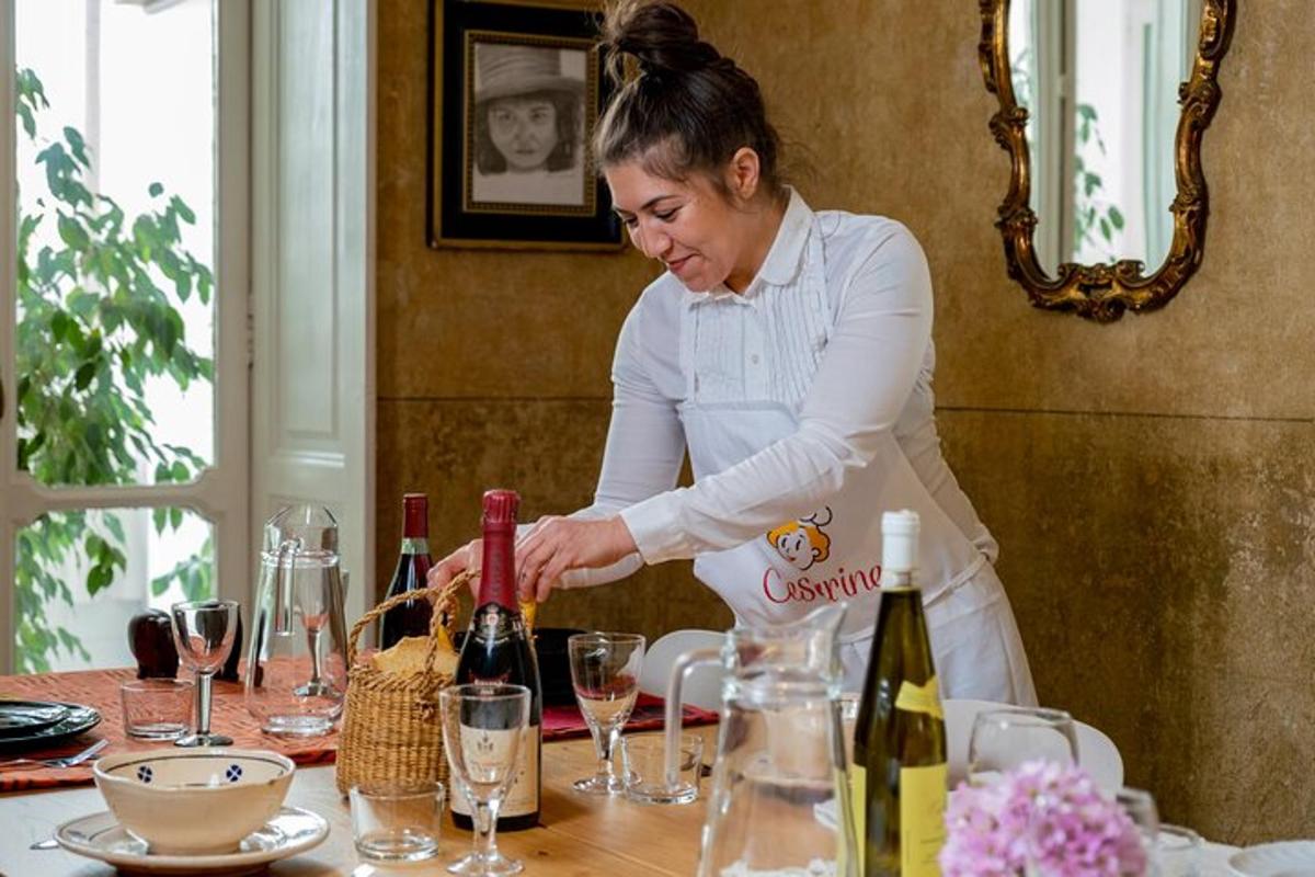 o femeie care stă deasupra unei mese cu sticle de vin