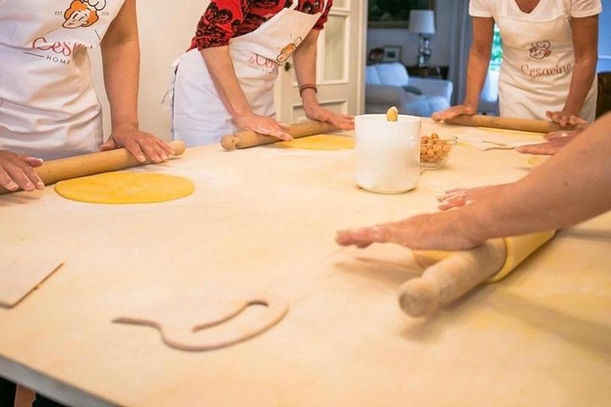 un gruppo di persone in piedi attorno a un tavolo con l'impasto