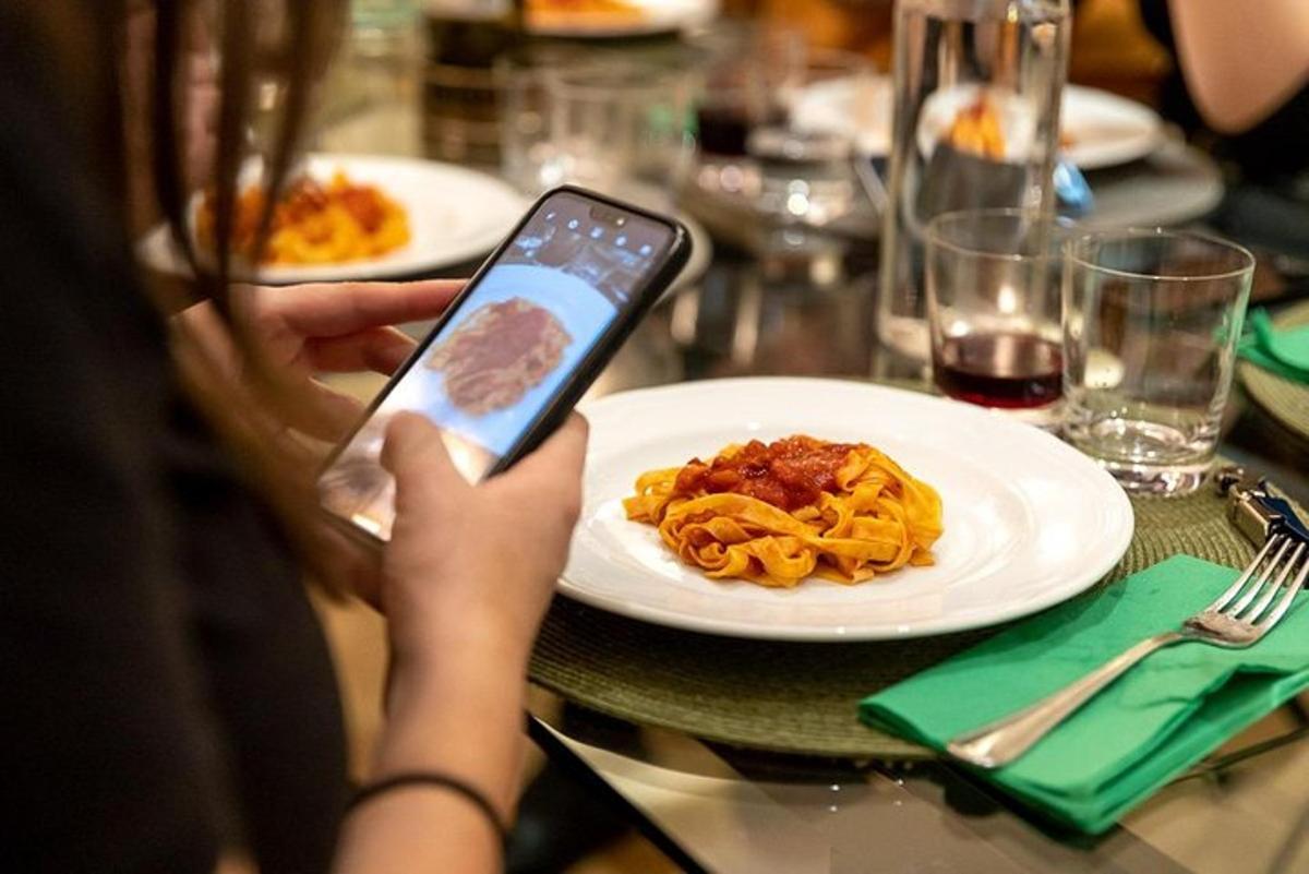 seseorang mengambil gambar sepiring pasta