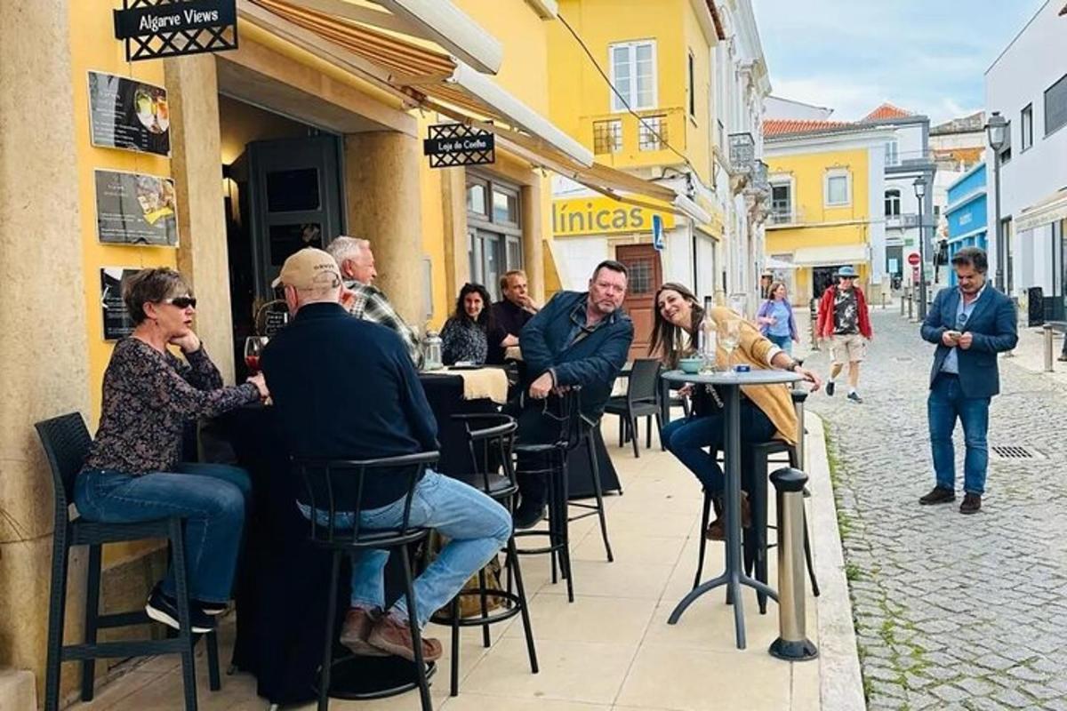 grupp inimesi, kes istuvad tänaval laudade taga