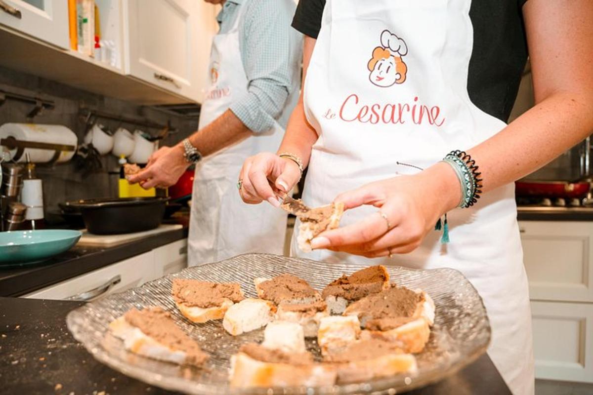 Dos personas en una cocina preparando comida en un plato.