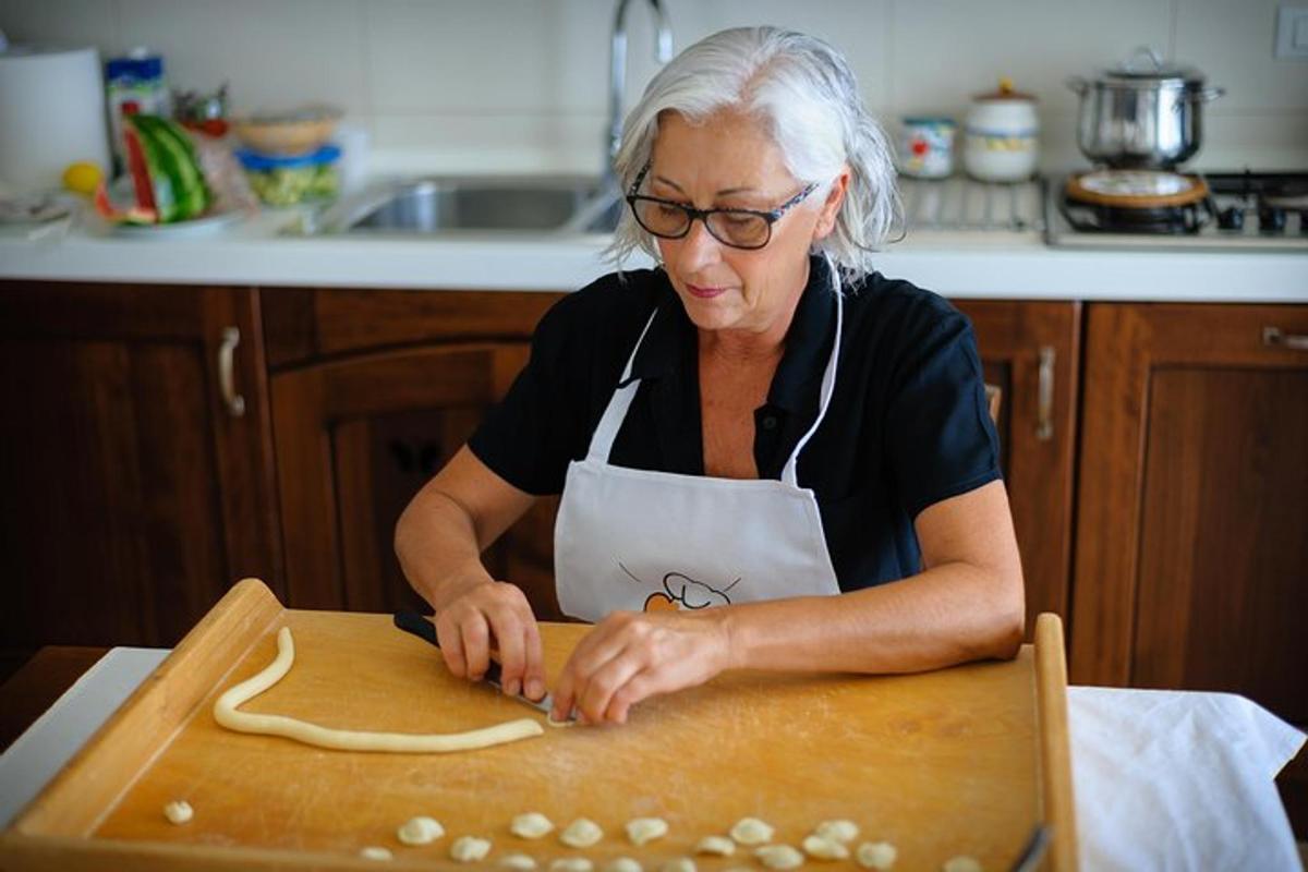 žena v kuchyni připravuje jídlo na prkénku