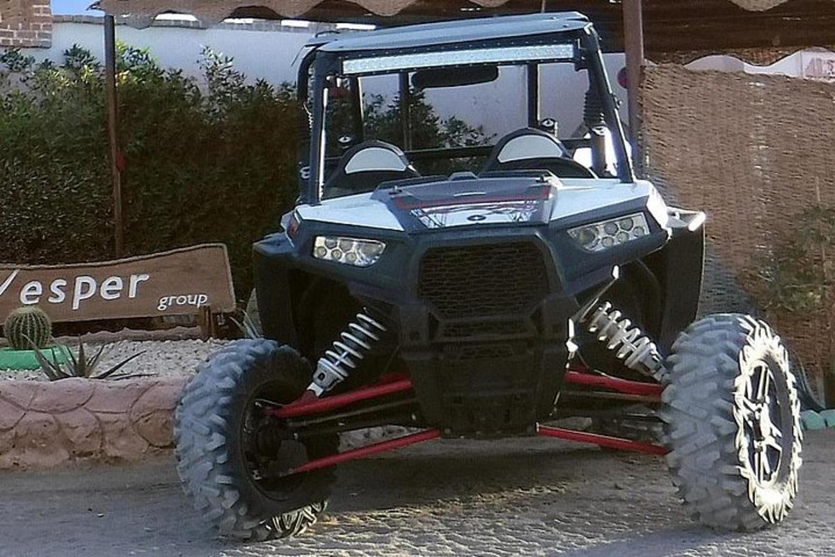 Egy kék ATV nagy gumikkal parkolva az utcán