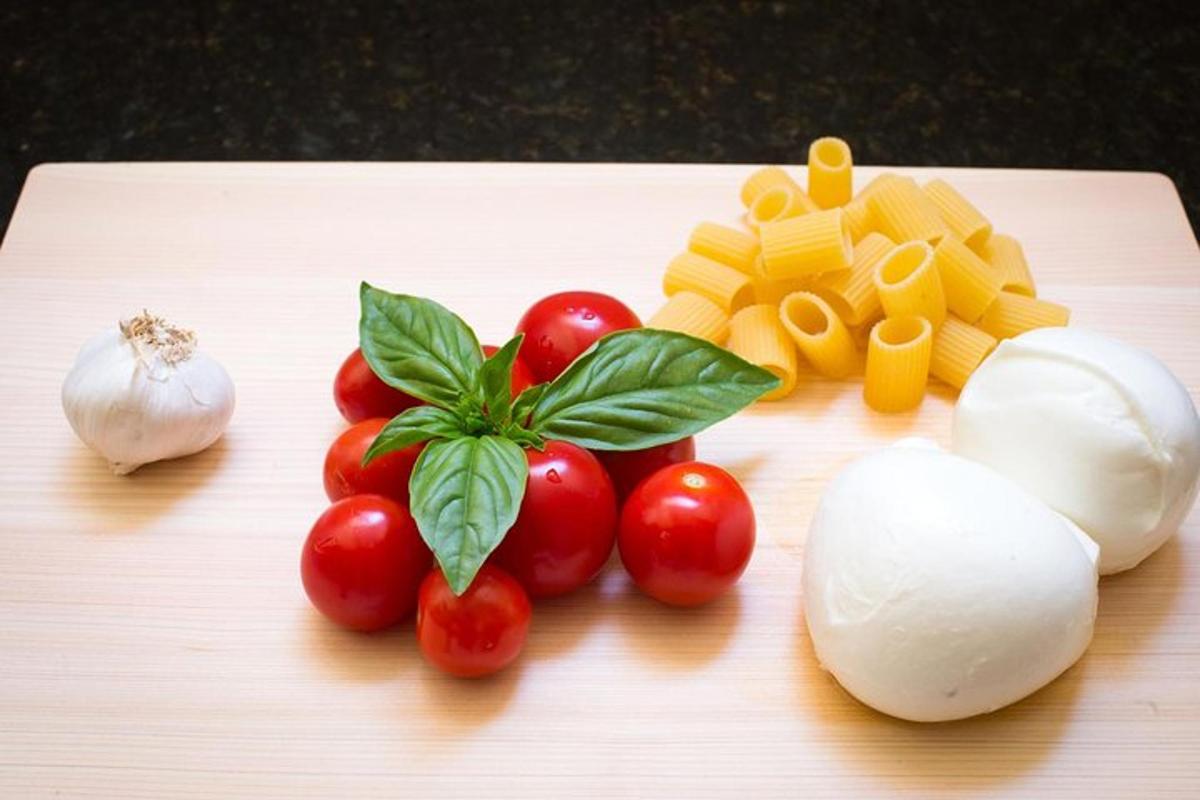 een snijplank met tomaten, kaas en groenten erop