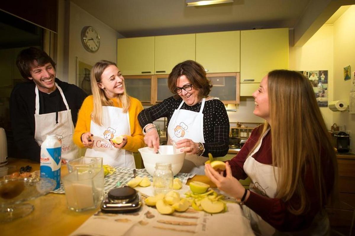um grupo de pessoas em pé em uma cozinha preparando comida