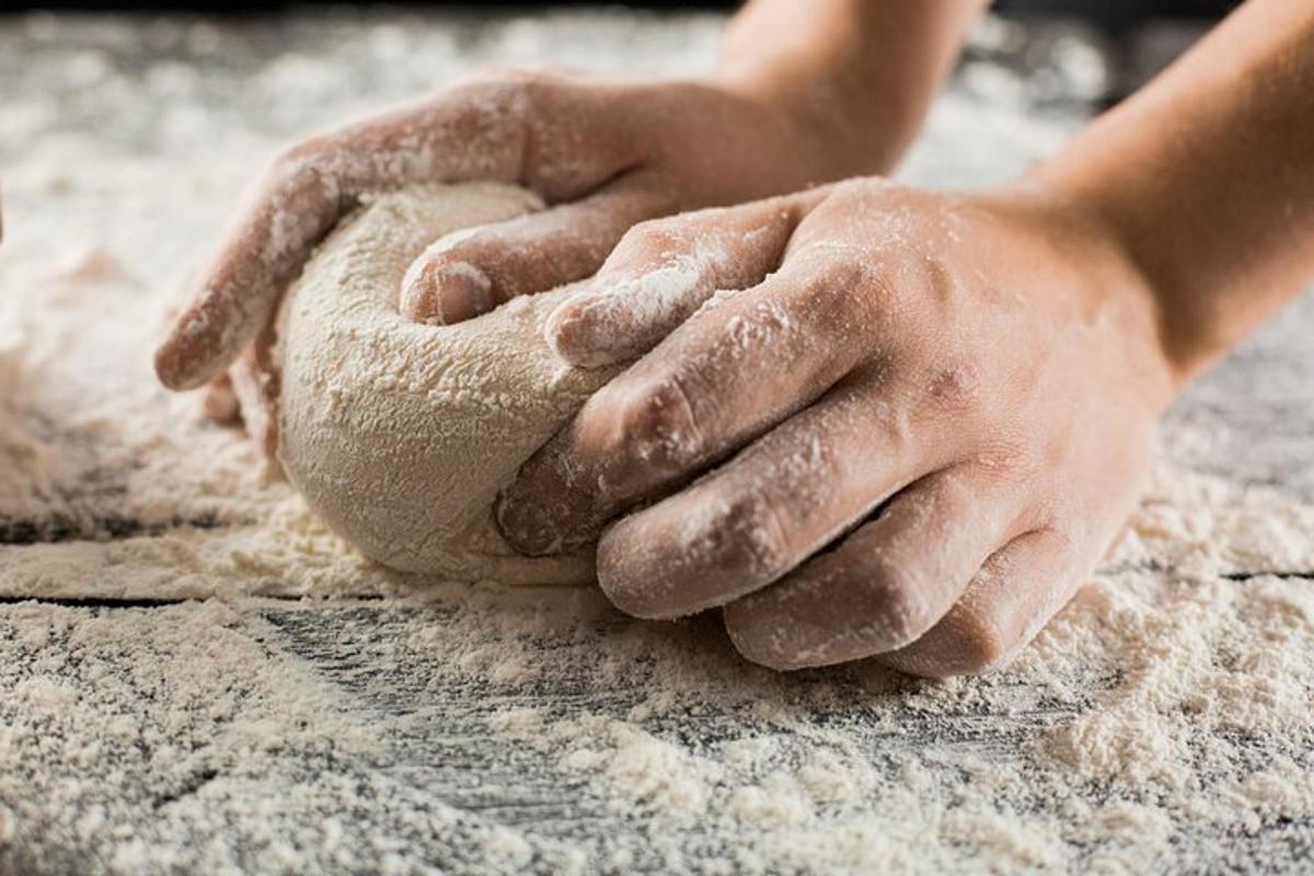 a child with their hands on a piece of dough