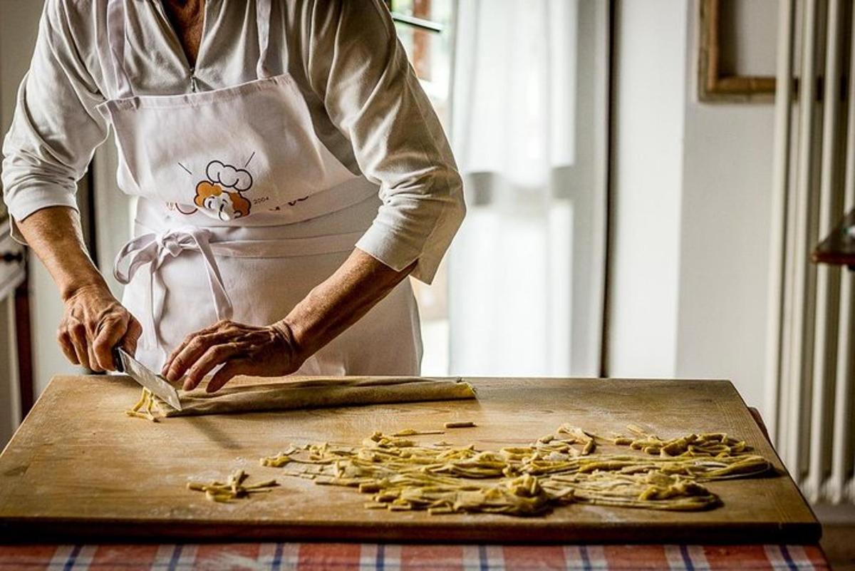 Una mujer en una cocina preparando comida en una tabla de cortar.