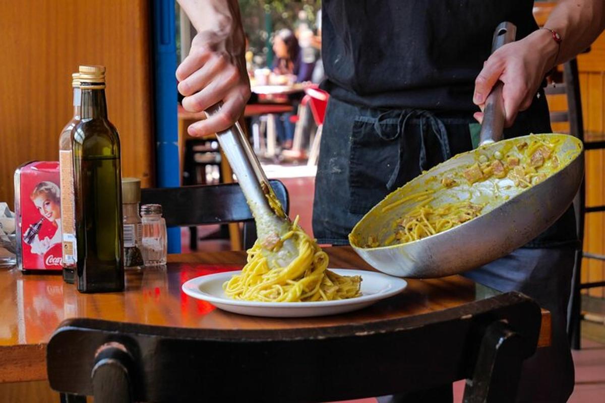 una persona che prepara un piatto di pasta su un tavolo