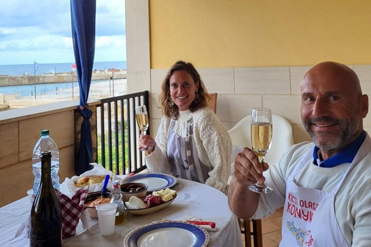 un uomo e una donna seduti a un tavolo con bicchieri di vino
