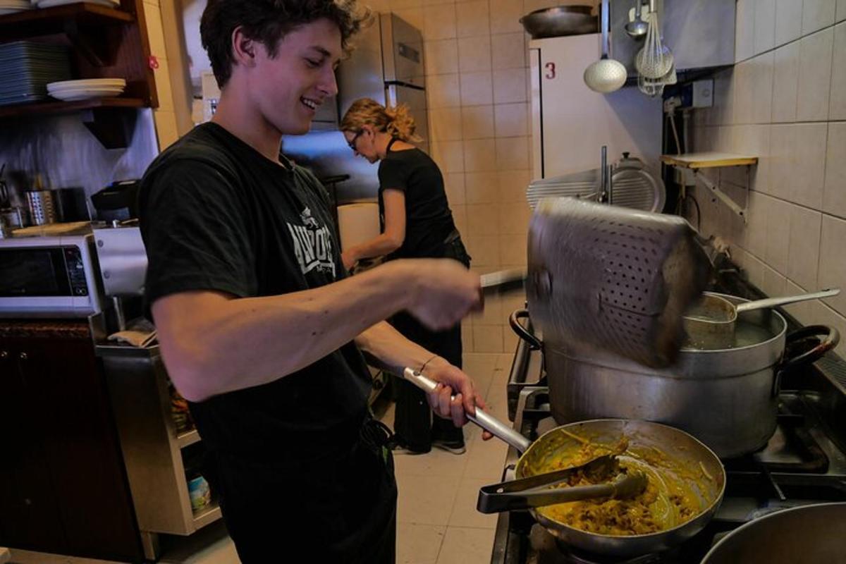 un uomo in cucina che prepara il cibo in una padella