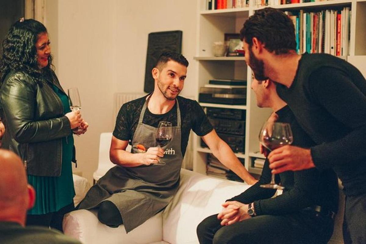 a group of people standing in a living room holding wine glasses