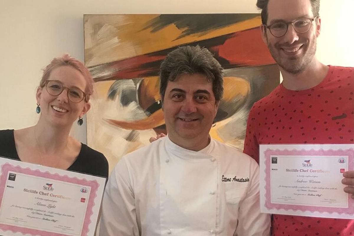 un uomo e una donna che tengono dei certificati davanti a un dipinto