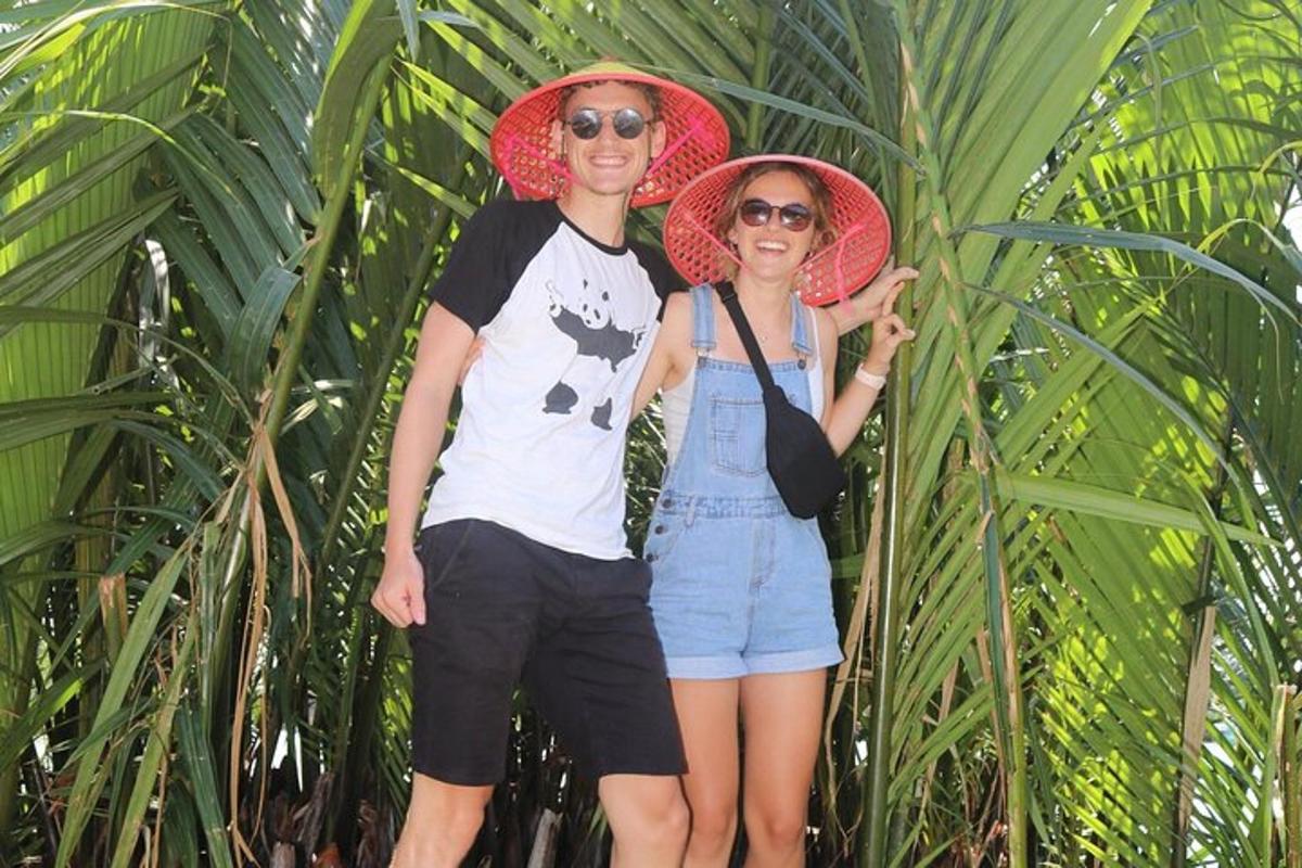 Un hombre y una mujer de pie frente a una palmera