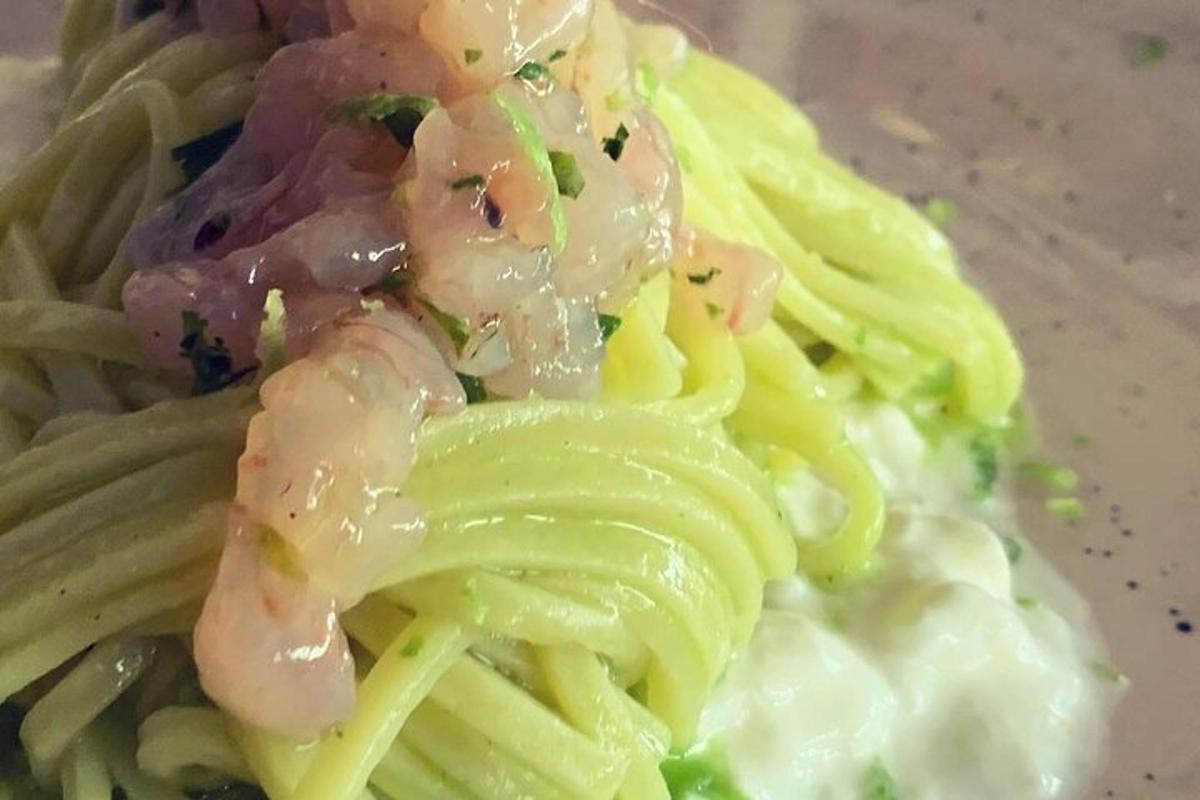 un piatto di pasta con gamberi sopra