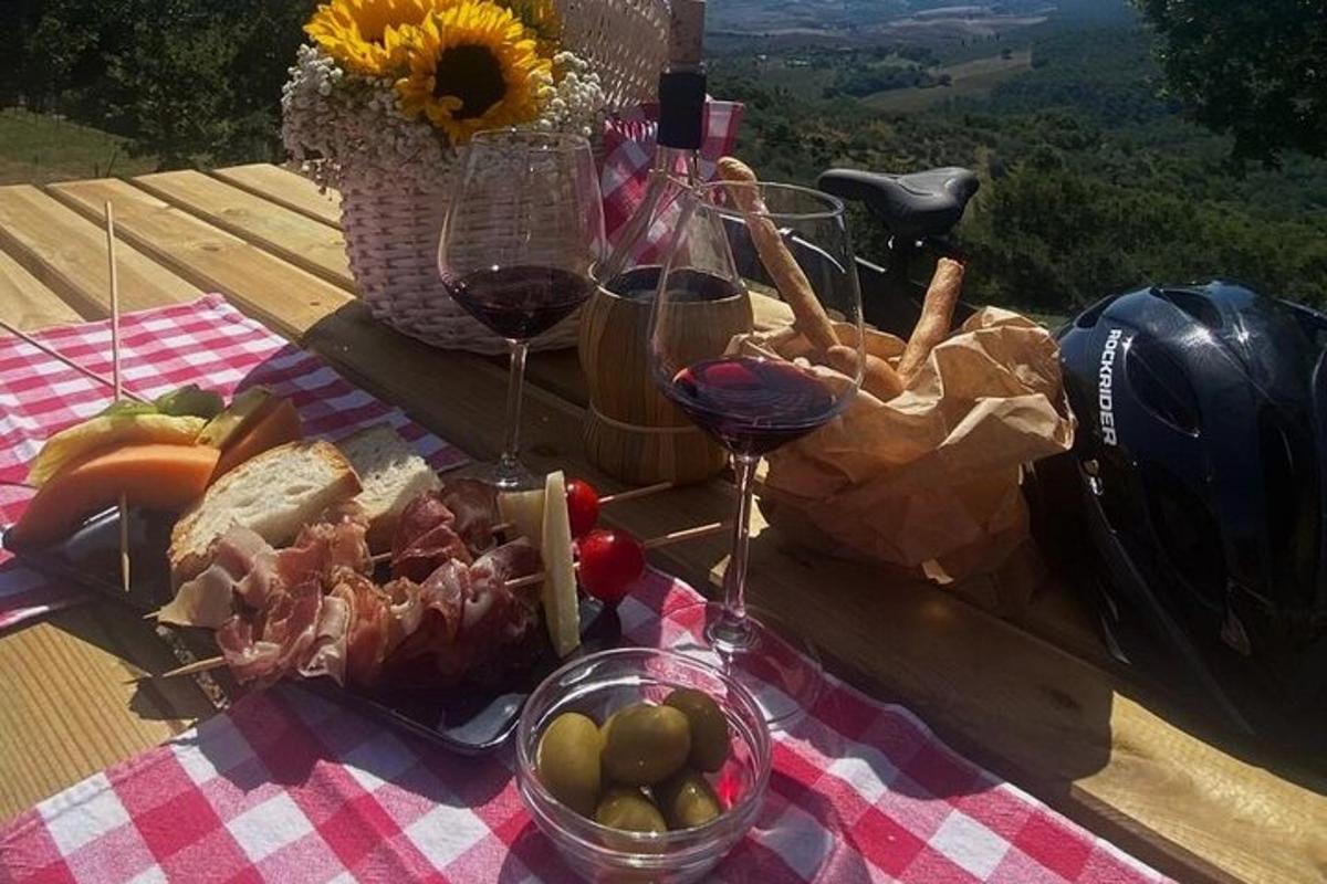 a picnic with wine glasses and food on a table