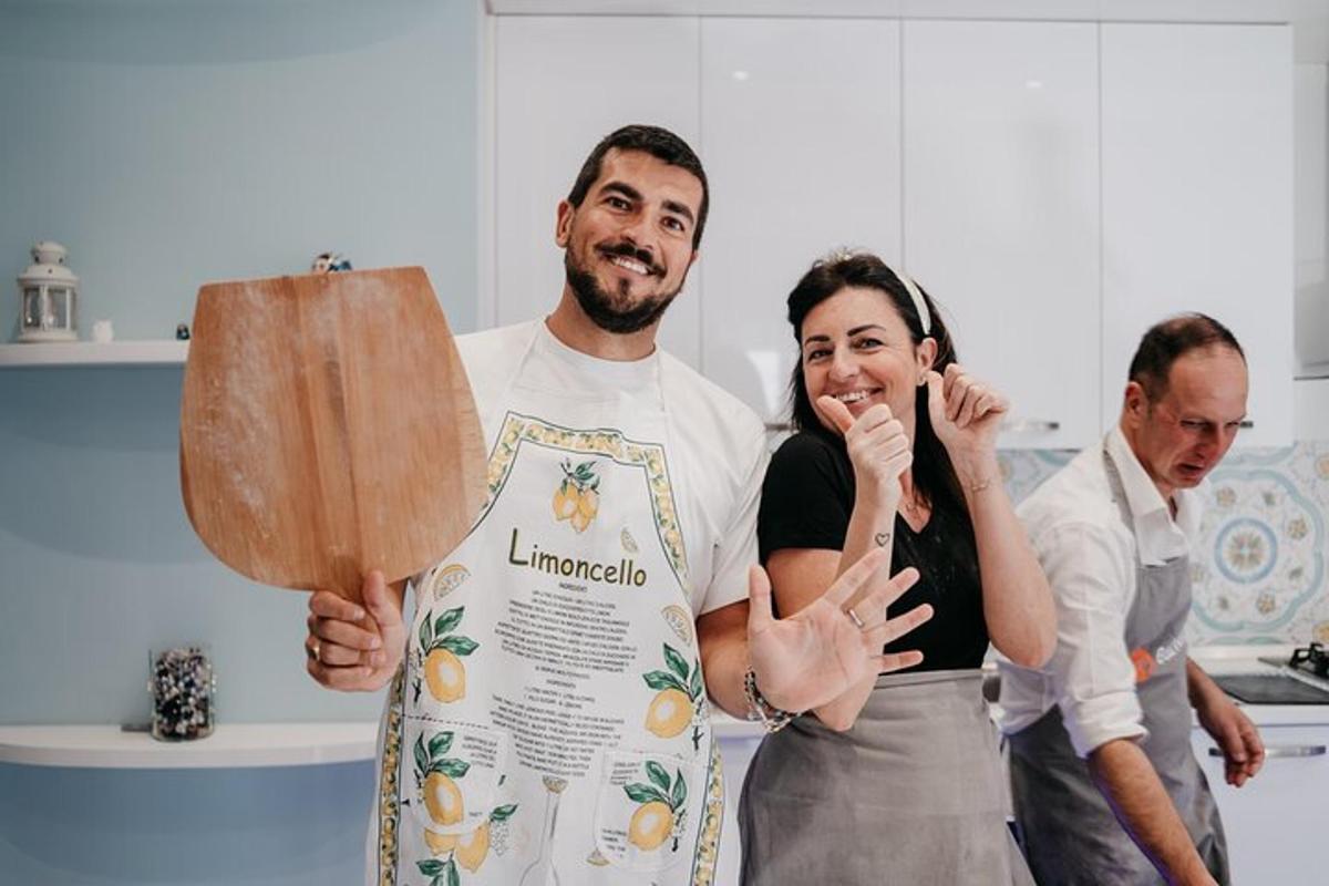 um homem e uma mulher em uma cozinha segurando uma pá de madeira