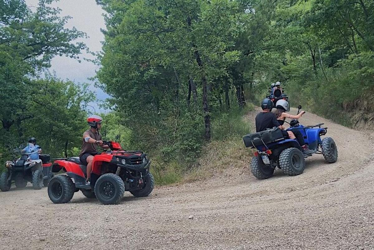 skupina lidí jedoucích na čtyřkolkách po nezpevněné cestě