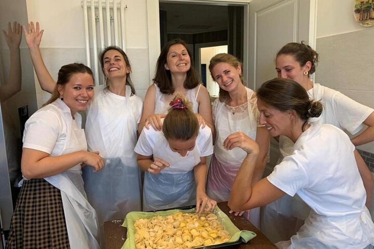 hópur kvenna stendur í kringum barn fyrir framan köku