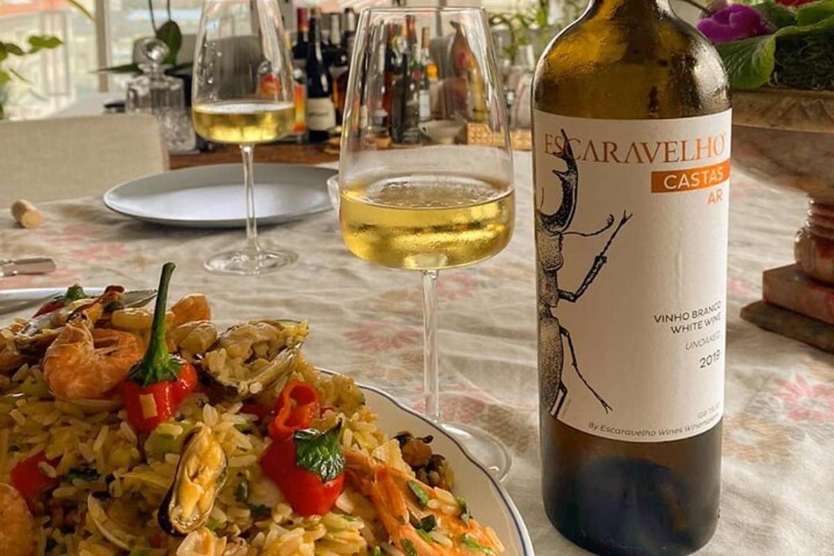 en tallerken med mat med en flaske vin og vinglass