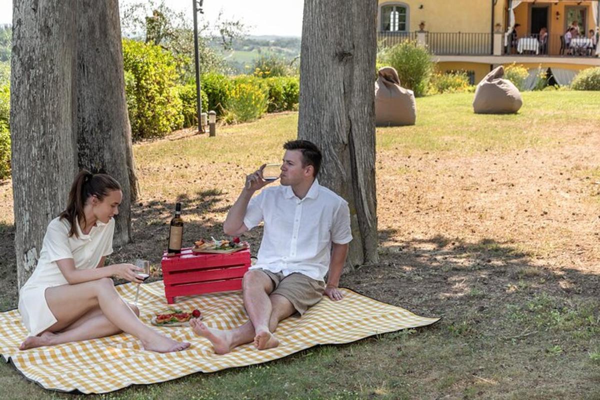 moški in ženska sedita na odeji za piknik