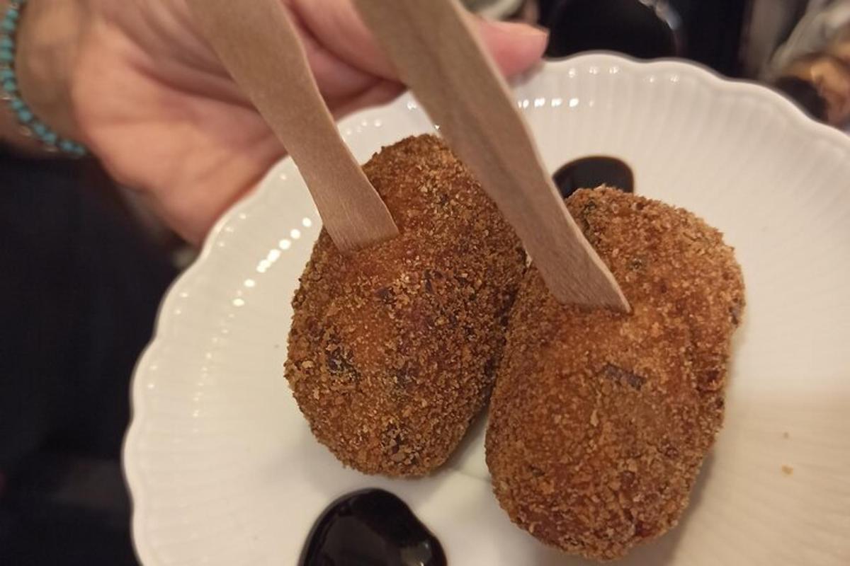 una persona que sostiene un plato con dos piezas de comida