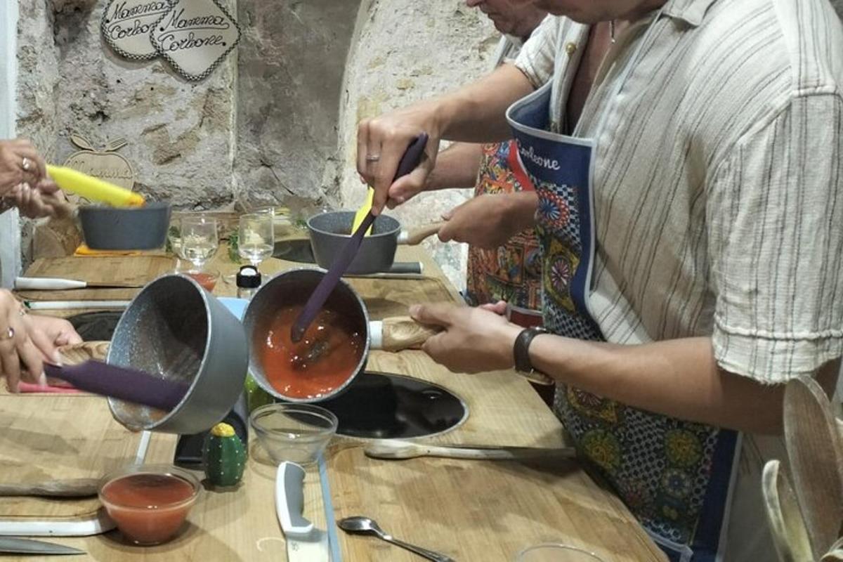 skupina lidí stojících kolem stolu a připravujících jídlo