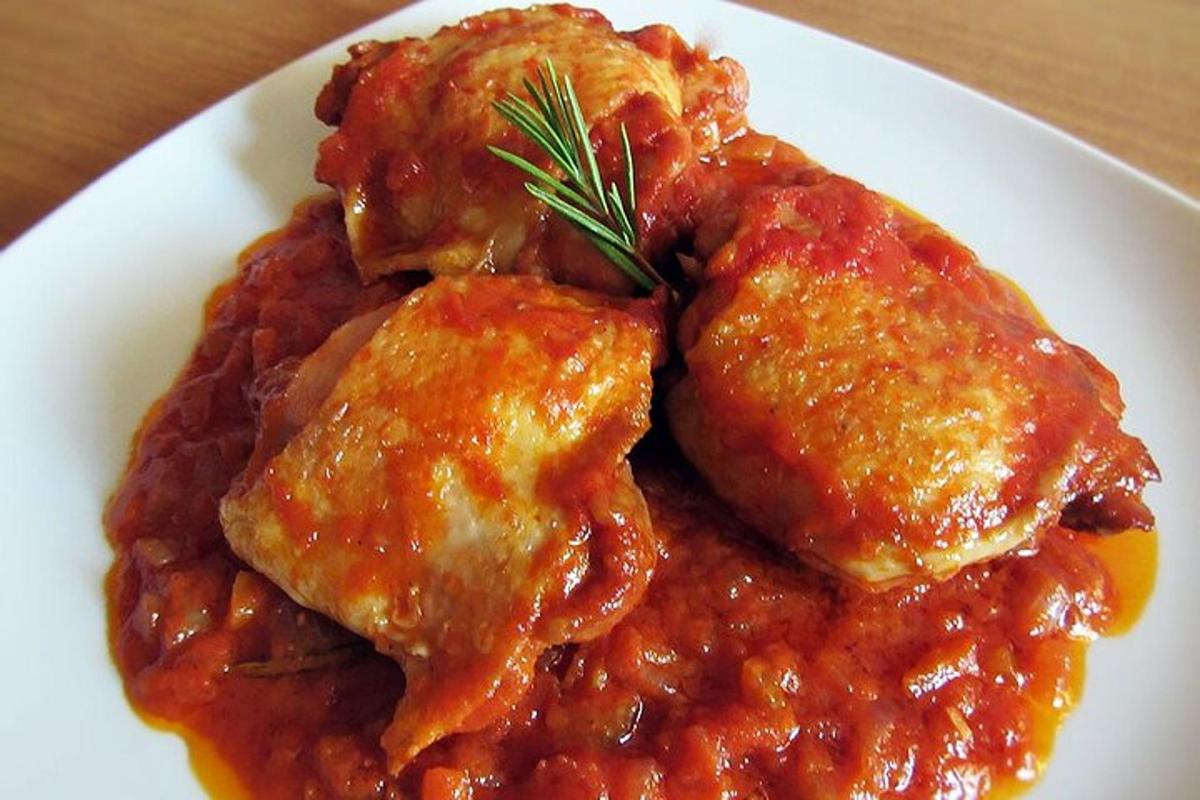 um prato branco de comida com carne e molho