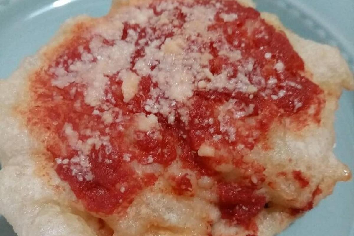 egy darab pizza szósszal és sajttal egy tányéron