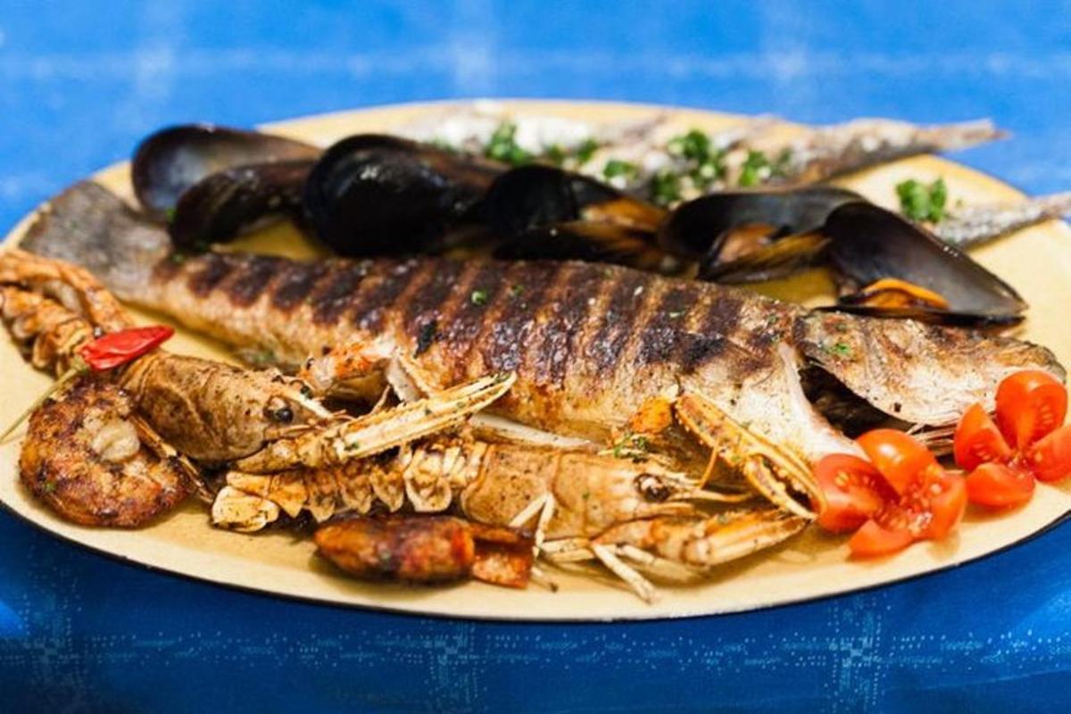 a plate of food with seafood on a blue table