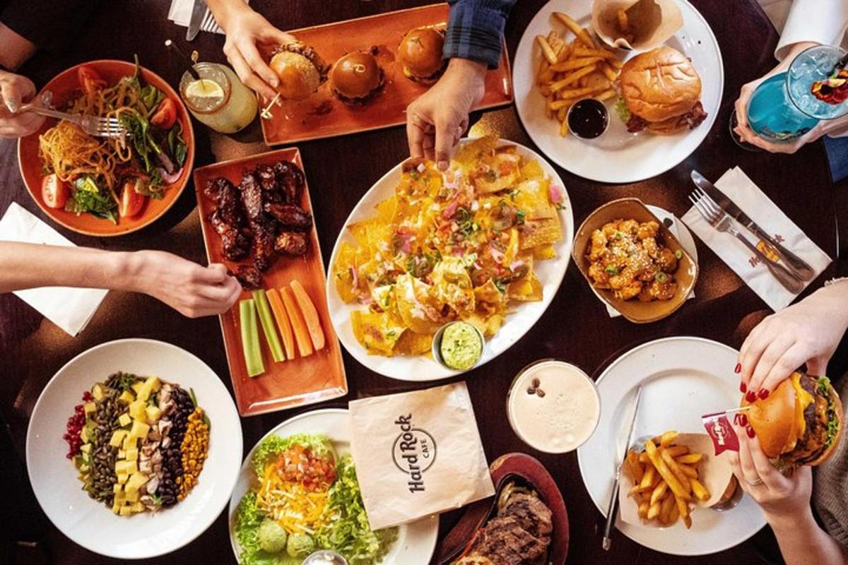 a group of people sitting around a table with plates of food