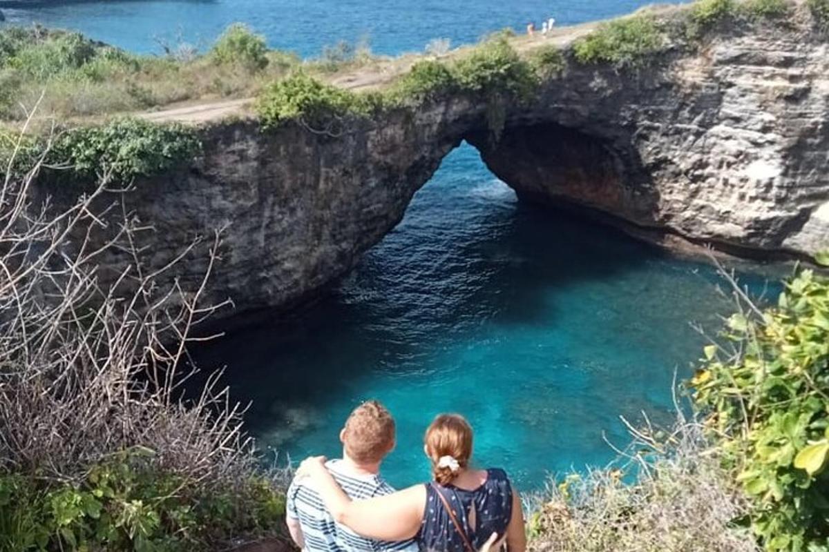 un uomo e una donna seduti su una scogliera vicino a una grotta