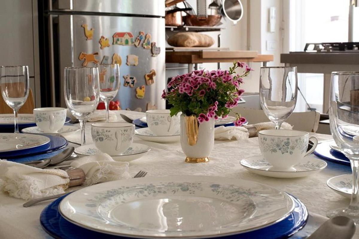 et bord med tallerkener og glass og en vase med blomster