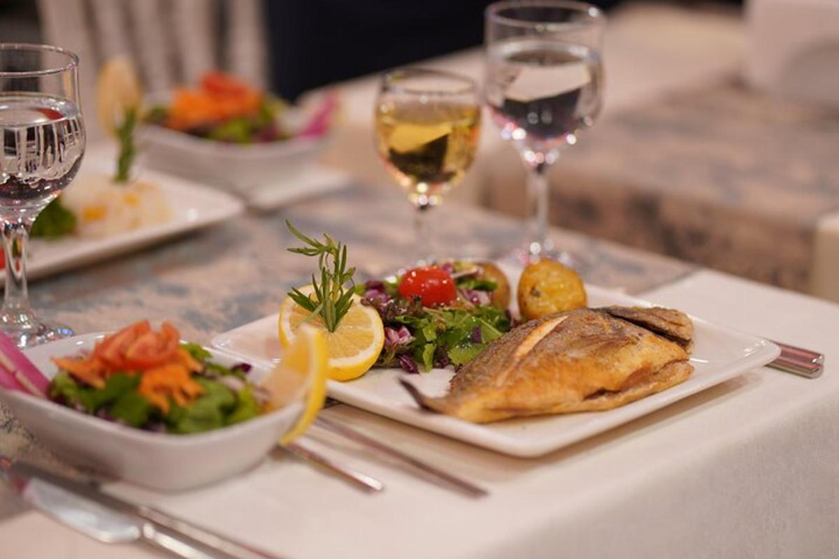 uma mesa com pratos de comida e copos de vinho